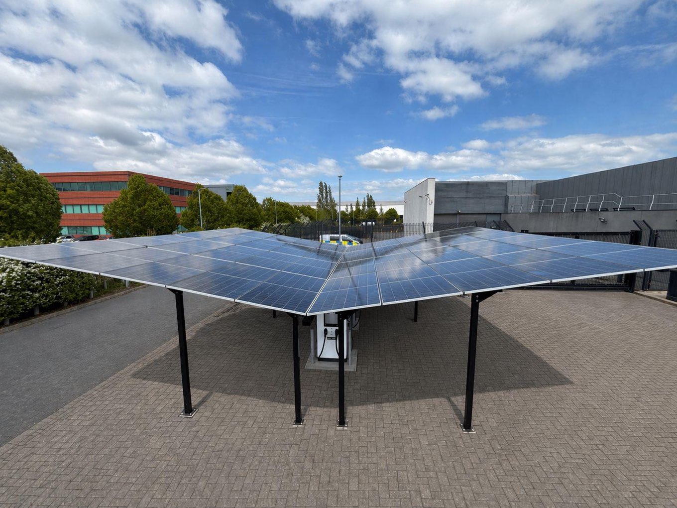 A Gullwing solar car park canopy with an EV charge point, installed on a commercial site.